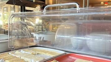 A buffet with various cheeses and pastries.