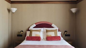 A hotel room with a large bed, two bedside lamps, and a wooden ceiling.