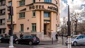 A multi-story hotel with a curved facade, multiple balconies, and a prominent entrance. - Hôtel Mercedes (Paris)