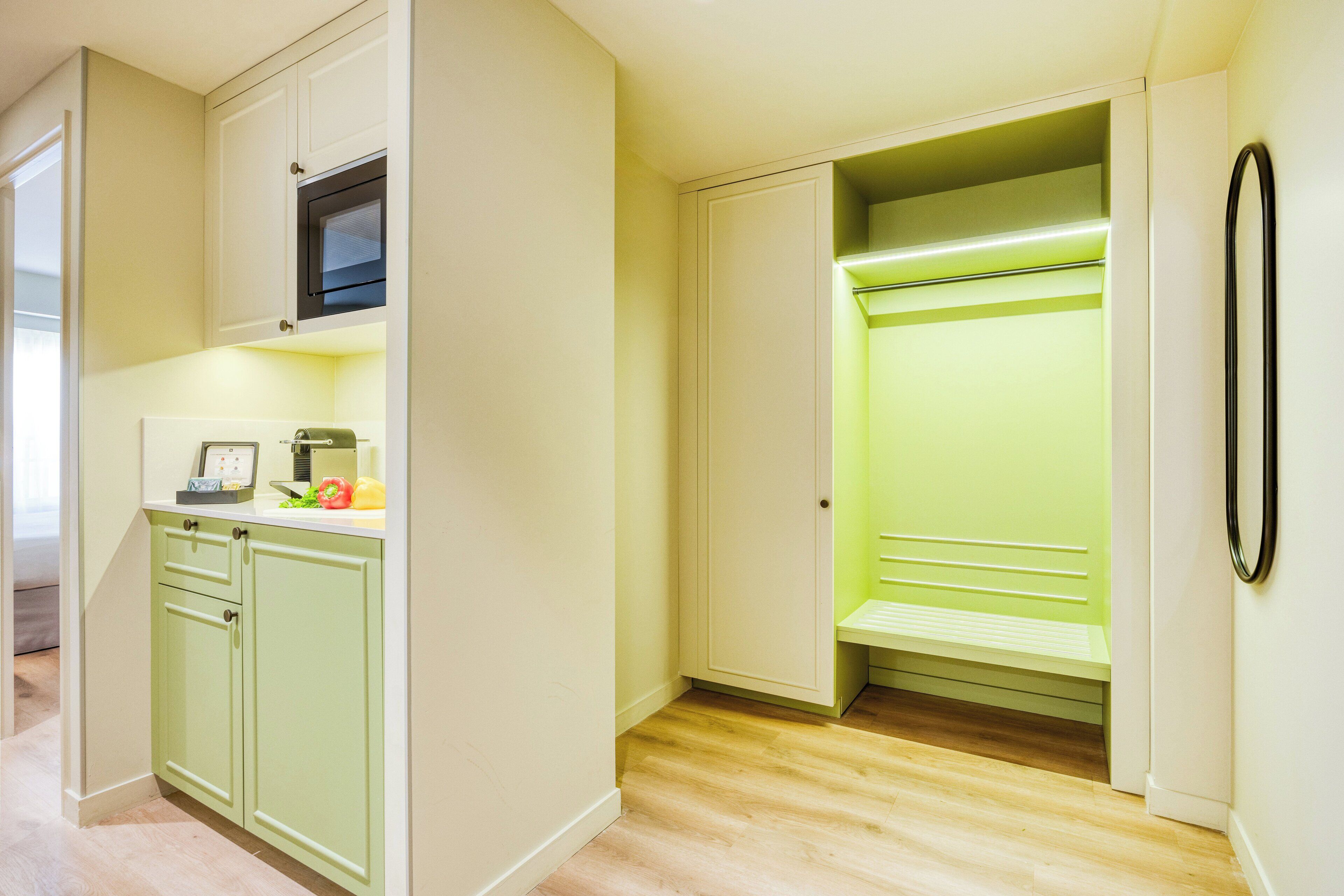 A kitchen with a microwave, toaster, and a green countertop.