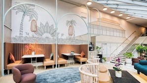 A modern interior with seating areas, a staircase, and a mural. - Citadines Les Halles Paris (Paris)