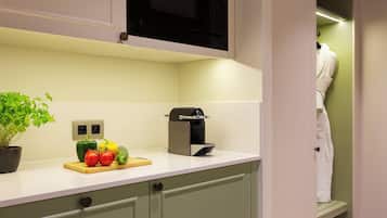 A kitchen with a microwave, a toaster, and a plant with vegetables on the counter.