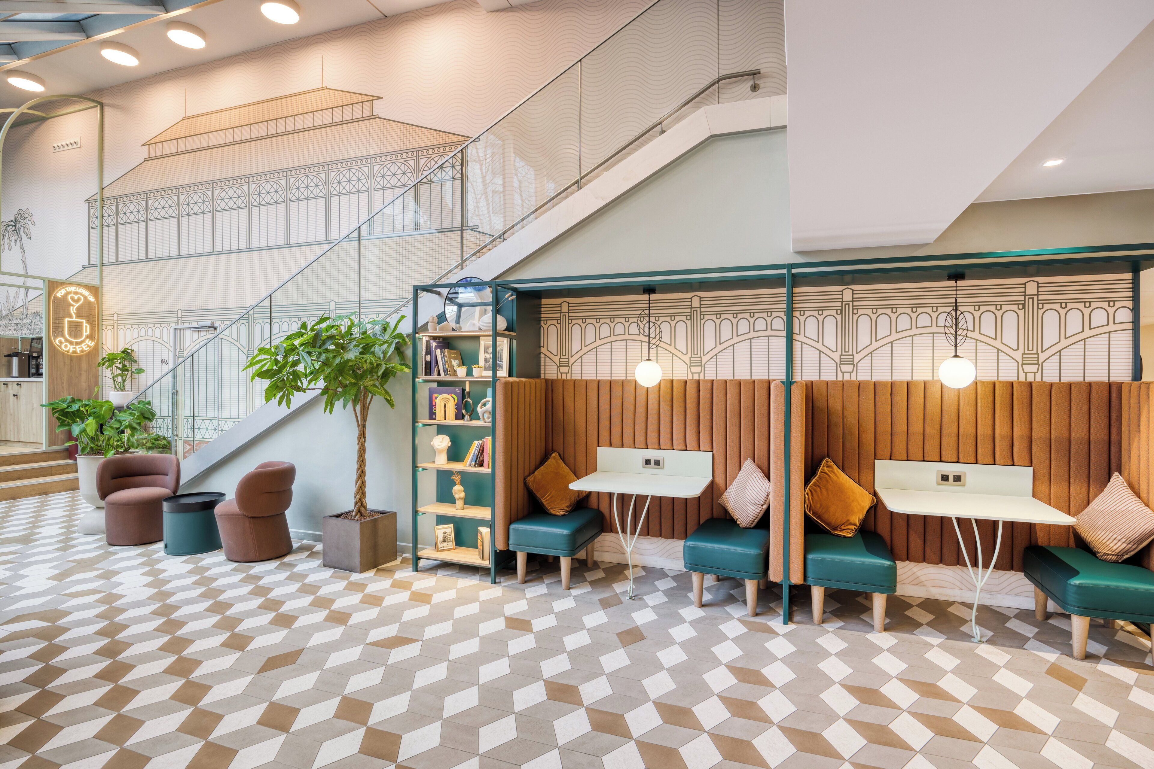 Un hall d’entrée moderne avec un sol à motifs géométriques, des coins salon dotés de coussins verts et un escalier avec une rampe en verre.