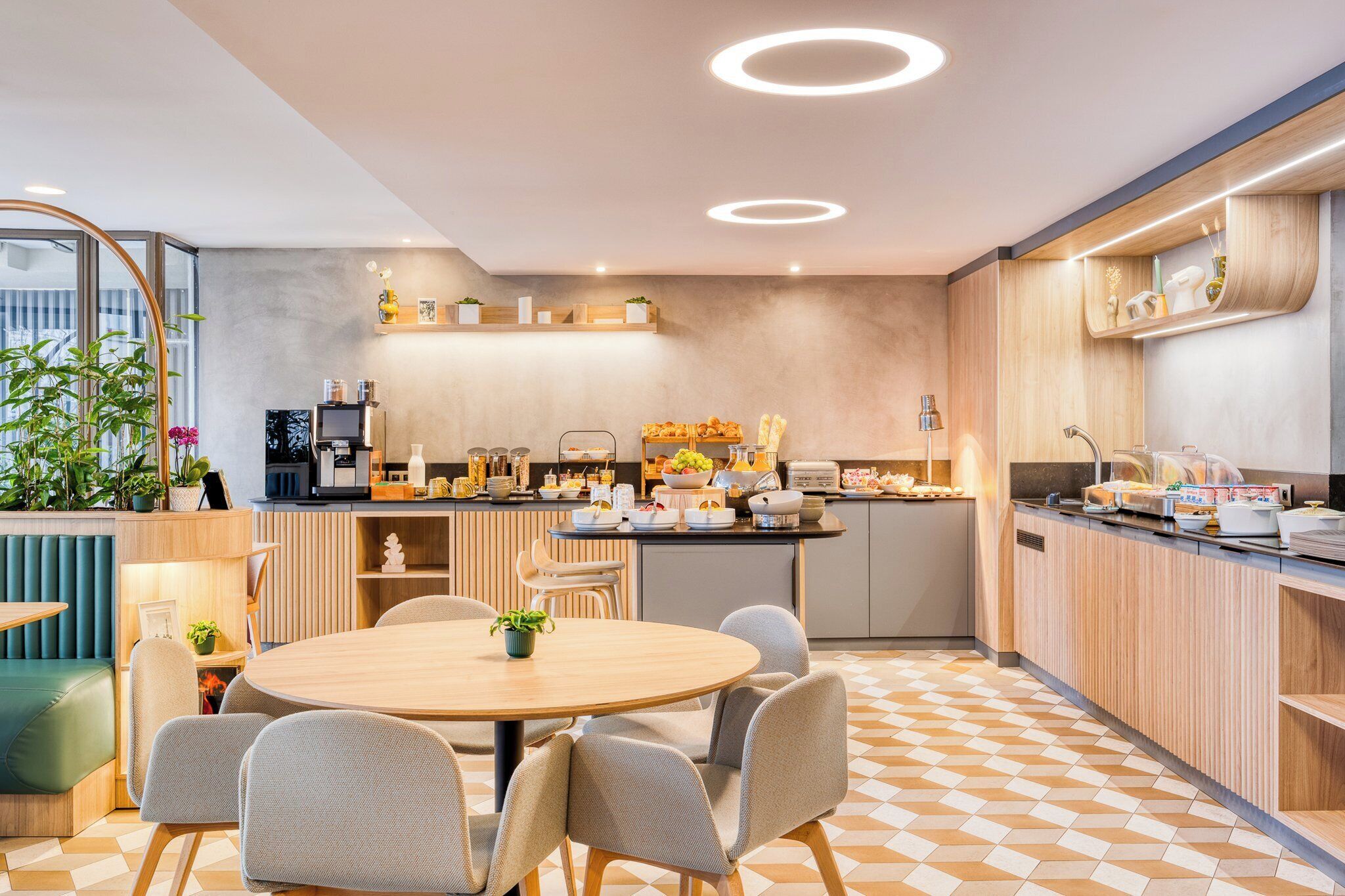 A modern kitchen with a round dining table, chairs, and a variety of appliances and food items.