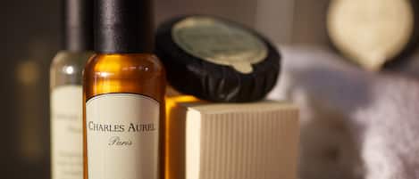 A bottle of Charles Aurel Paris bath shower gel, a compact, and a toiletry box.