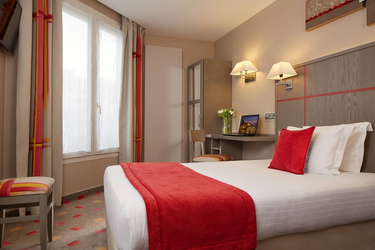 Ein Hotelzimmer mit einem großen Bett, einem Schreibtisch und einem Stuhl.