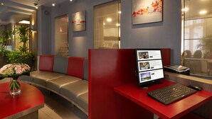 A modern reception area with a desk, computer, and seating area. - Hôtel Alizé Grenelle Tour Eiffel (Paris)