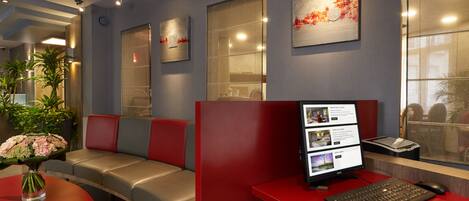 A modern reception area with a desk, computer, and seating area.