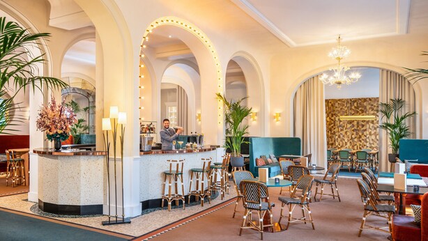 A hotel lobby with a bar area, seating arrangements, and decorative lighting. - Holiday Inn Paris - Gare de Lyon Bastille by IHG (Paris)