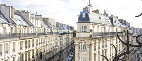 A row of classic European-style buildings with uniform architecture, featuring balconies and large windows.