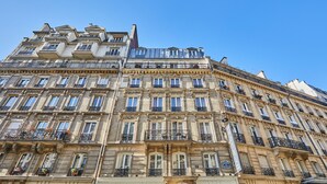 A multi-story hotel with a classic architectural style, featuring numerous balconies and large windows. - Hotel Berne Opera (Paris)