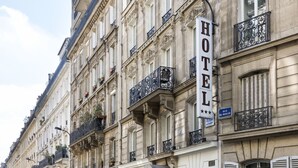 A hotel with ornate balconies, a prominent 'HOTEL' sign, and a 'RUE DE MOSCOU' sign. - Hotel Berne Opera (Paris)