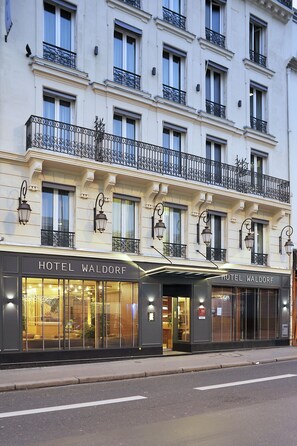 A hotel facade with multiple windows, balconies, and a sign reading "HOTEL WALDORF." - Hotel Waldorf Montparnasse (Paris)