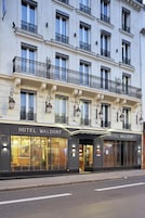 Fachada de hotel con varias ventanas, balcones y un letrero que dice "HOTEL WALDORF".