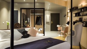 Een moderne hotelkamer met een groot bed, nachtkastje en een bureau.