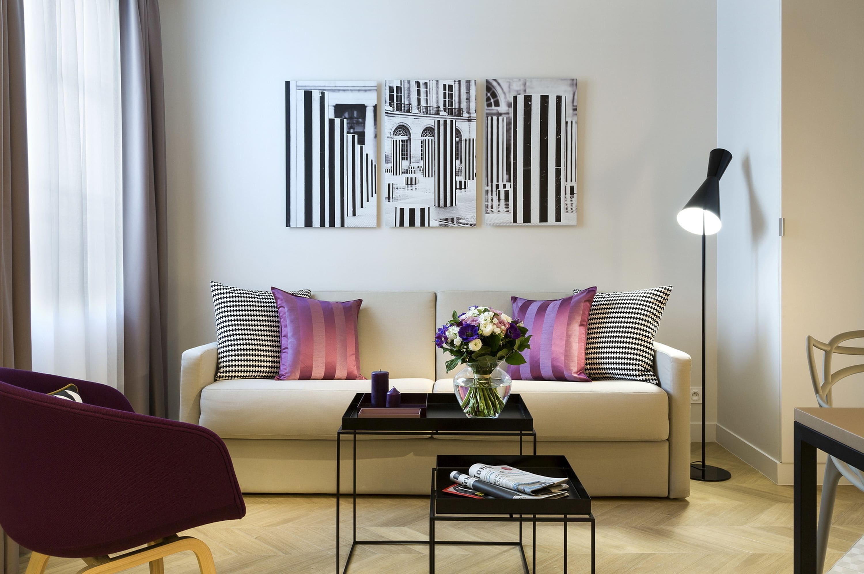 Un salon moderne avec un canapé, une table basse et un lampadaire.