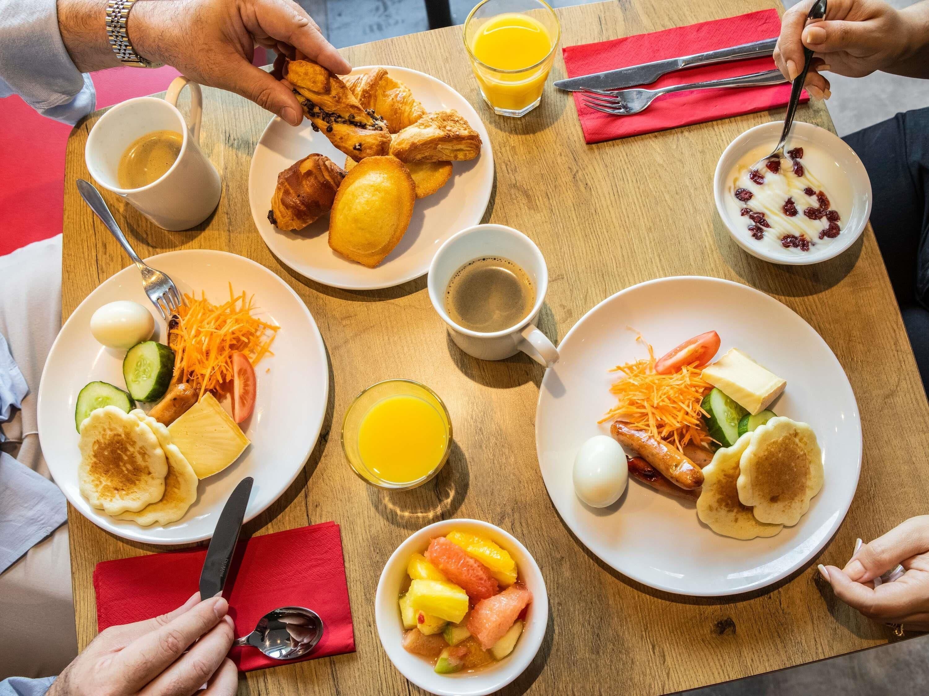 Un desayuno con diversas opciones, como pasteles, frutas y bebidas.