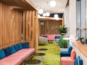 Relax in a stylish lounge area with a sofa, armchair, and coffee tables, surrounded by natural greenery.