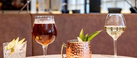 Trois verres remplis de boissons sur une table en marbre, dans un intérieur moderne.