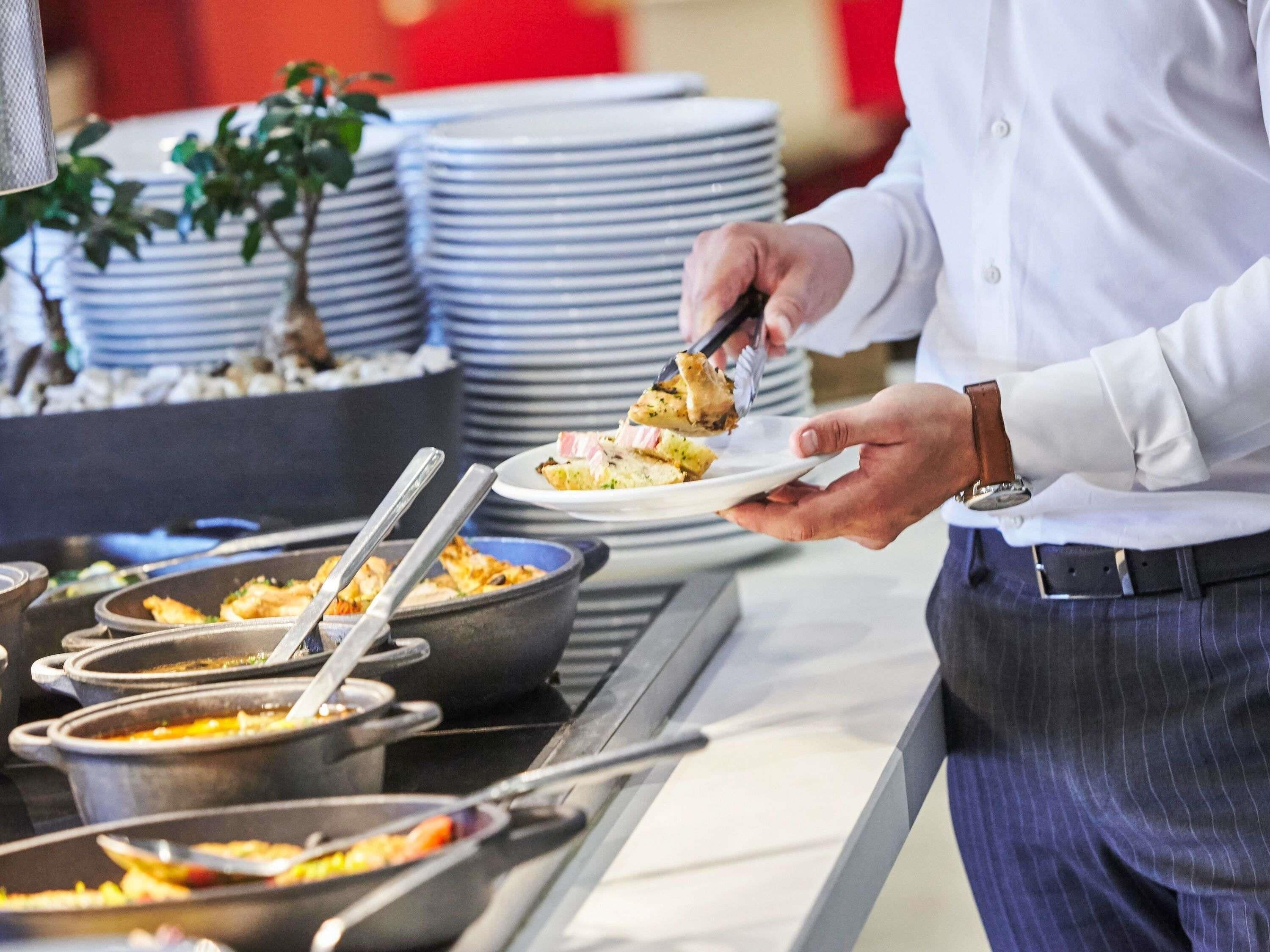 A buffet setup with multiple serving dishes and utensils.