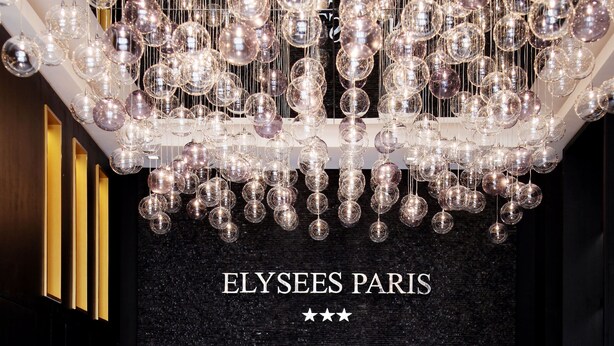 Un intérieur moderne avec un mur noir à texture, un canapé blanc et un lustre.