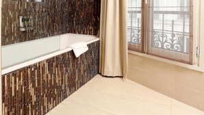 Une salle de bain moderne avec un grand miroir, une baignoire et un espace douche.
