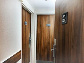 Um corredor com duas portas de madeira, cada uma com um número.