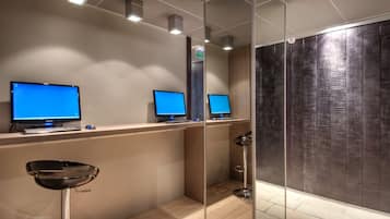A reception area with two computer monitors, a keyboard, and a chair.
