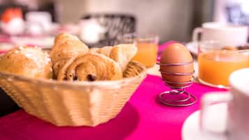 A breakfast setting with pastries, a basket, and a stand for an egg.
