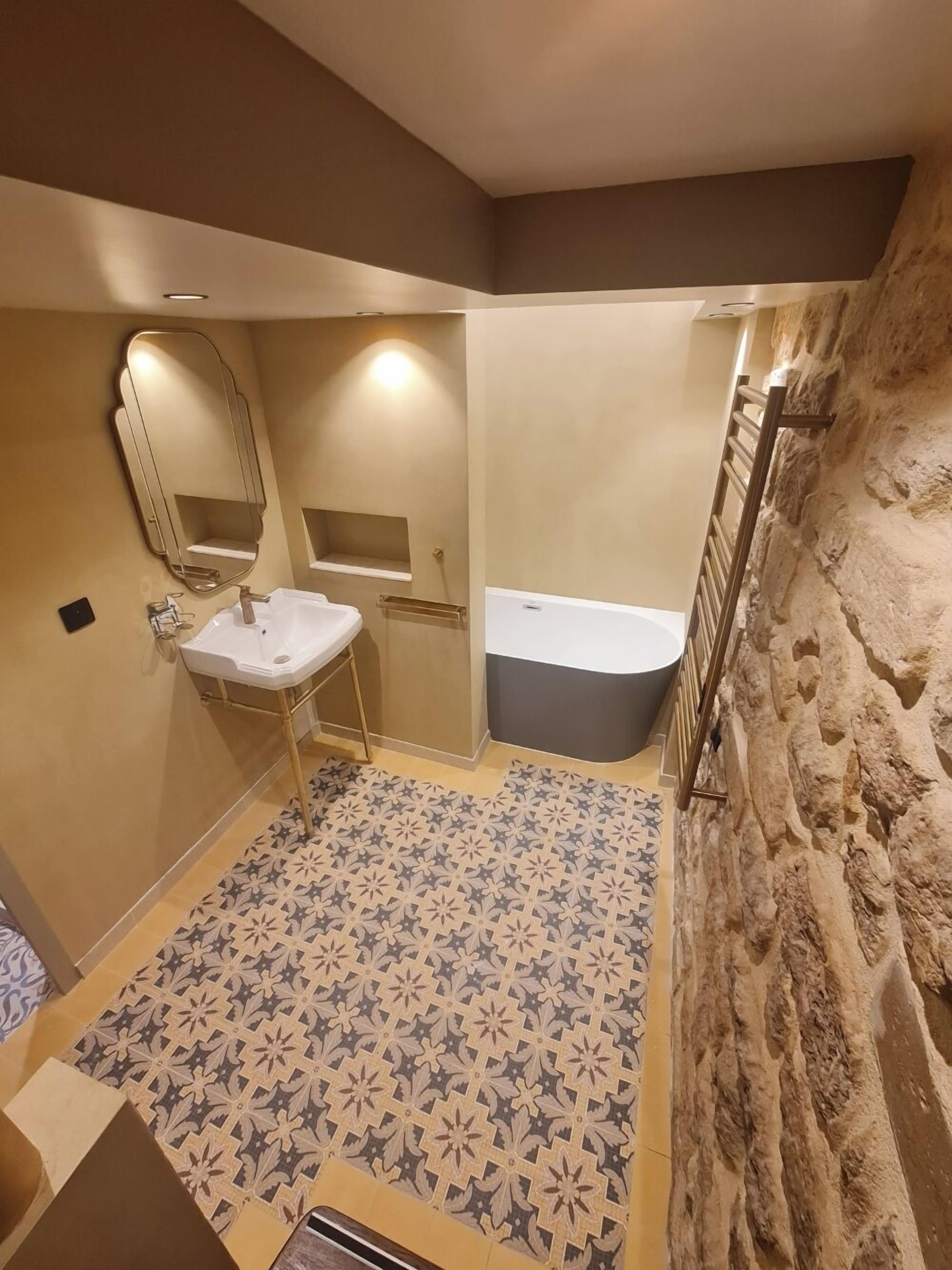 Un baño con lavamanos, espejo y bañera.
