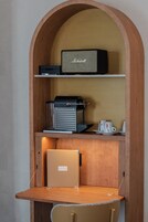A wooden desk with a laptop, a coffee machine, and a Marshall amplifier.