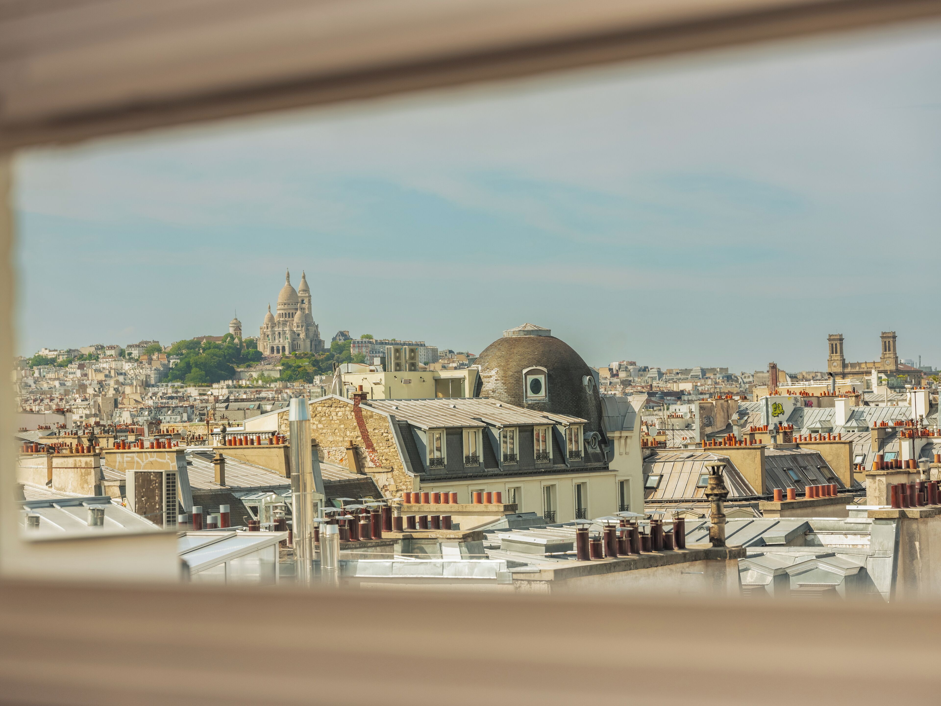 A cityscape with a prominent domed building and a cathedral in the background.