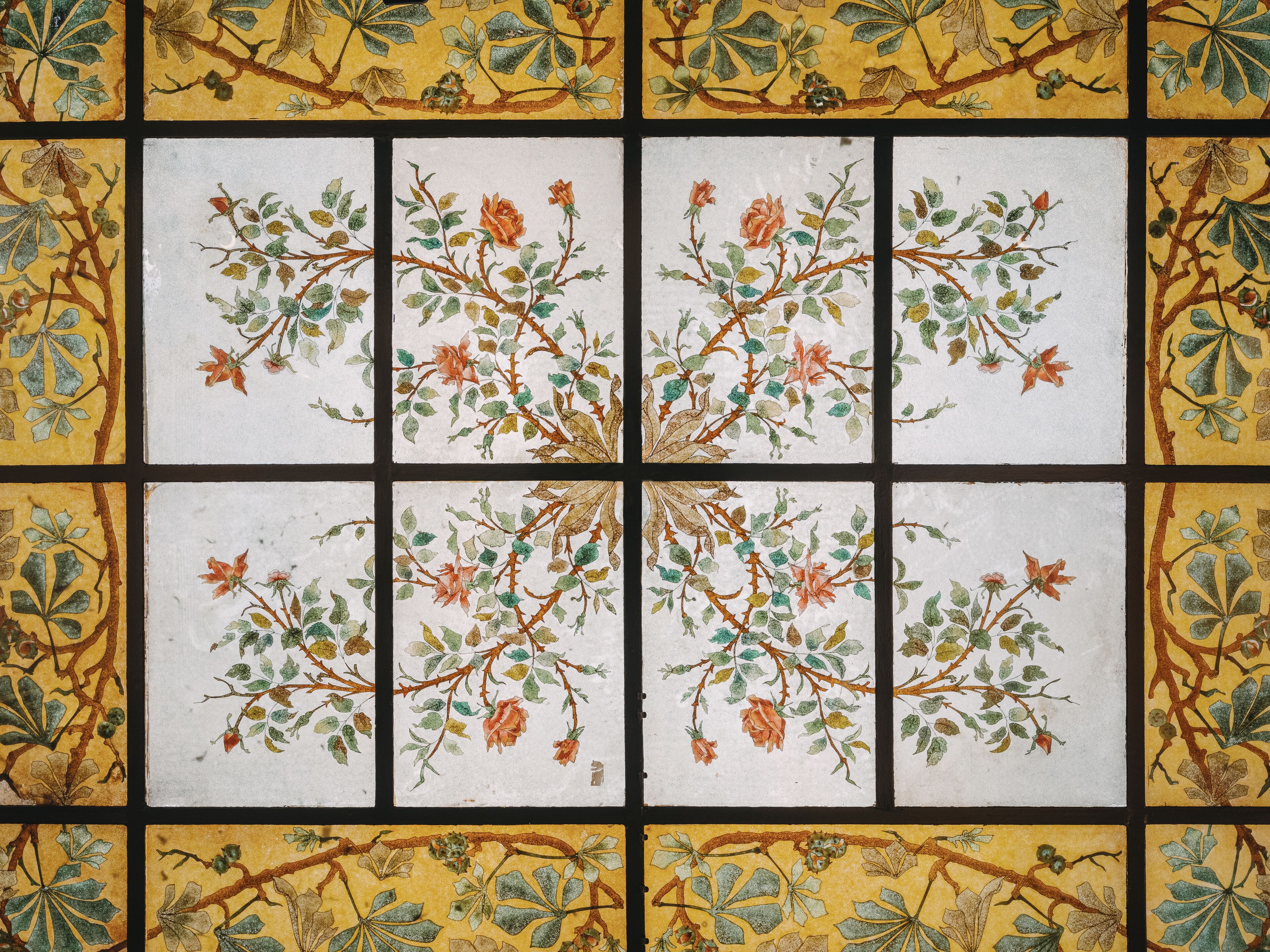 Una pared de azulejos con un diseño floral.
