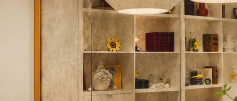 A modern interior with a black sofa, round tables, and a bookshelf with various decorative items.