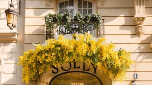 Fachada de edificio con una entrada arqueada grande que dice "SOLLY".