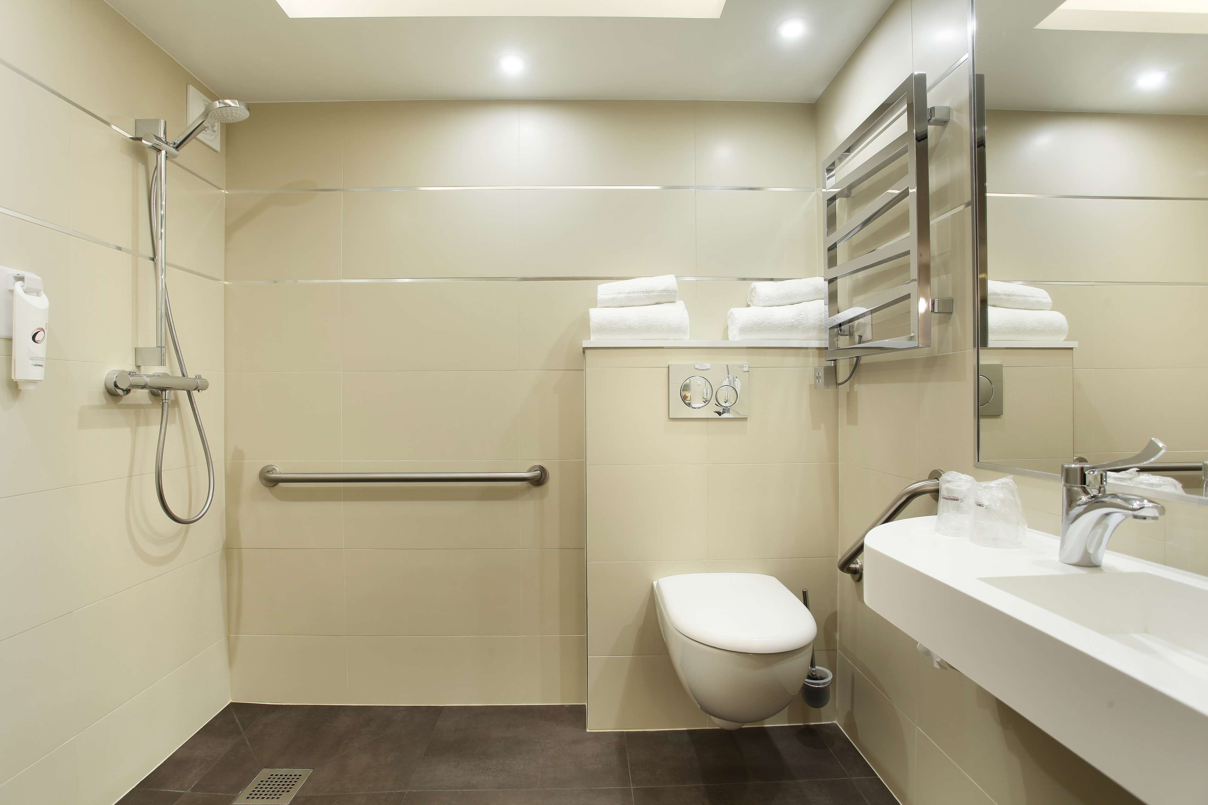 A modern bathroom with a shower, toilet, and sink.