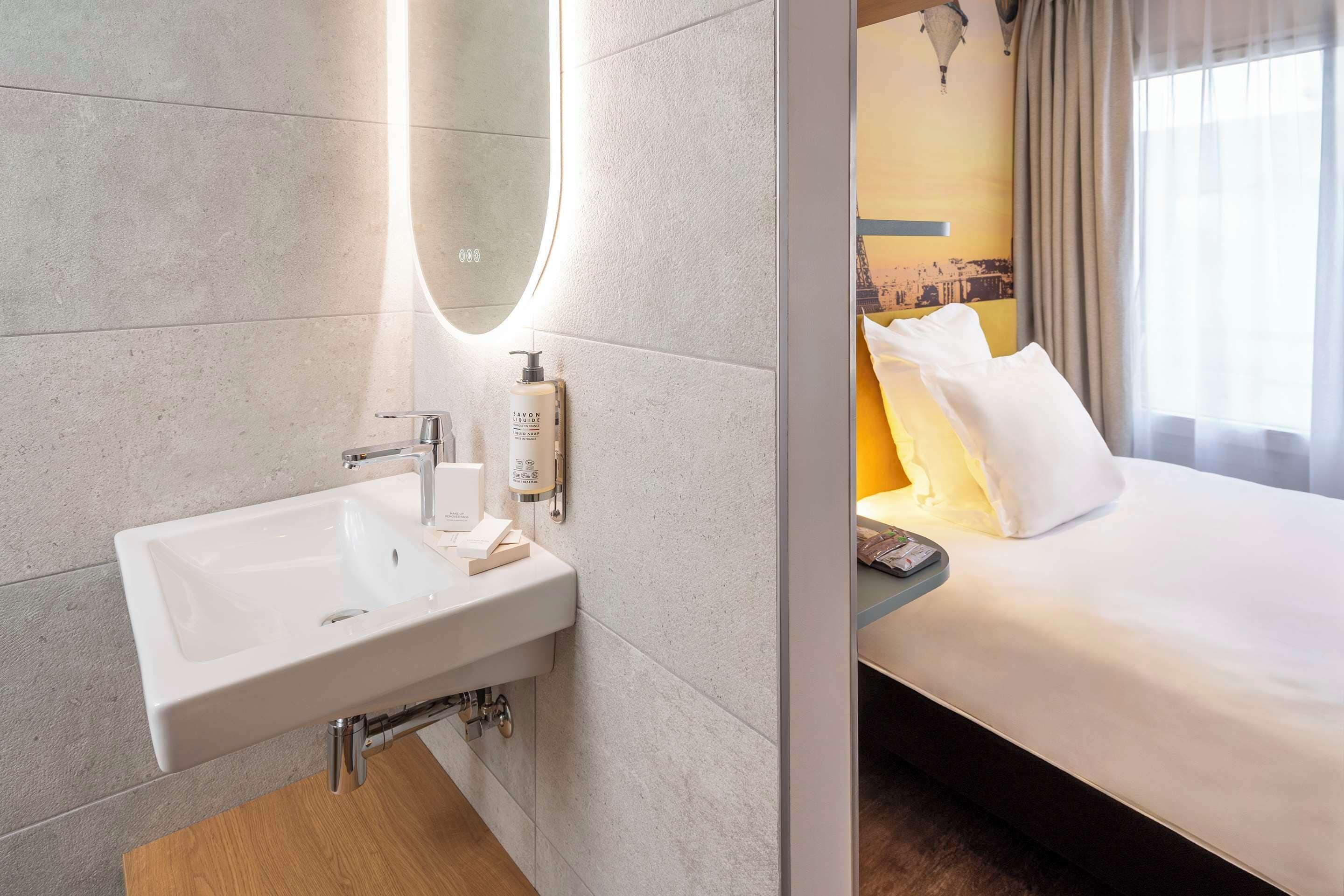 Ein Badezimmer mit Waschbecken, Spiegel und Toilettenartikeln.