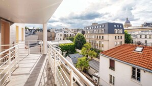 A balcony with a view of a cityscape, including buildings with a dome and a tower. - Hotel Apolonia Paris Mouffetard, Sure Hotel Collection by BW (Paris)