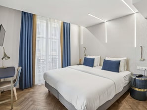 Une chambre d’hôtel moderne avec un grand lit, un bureau et une chaise.