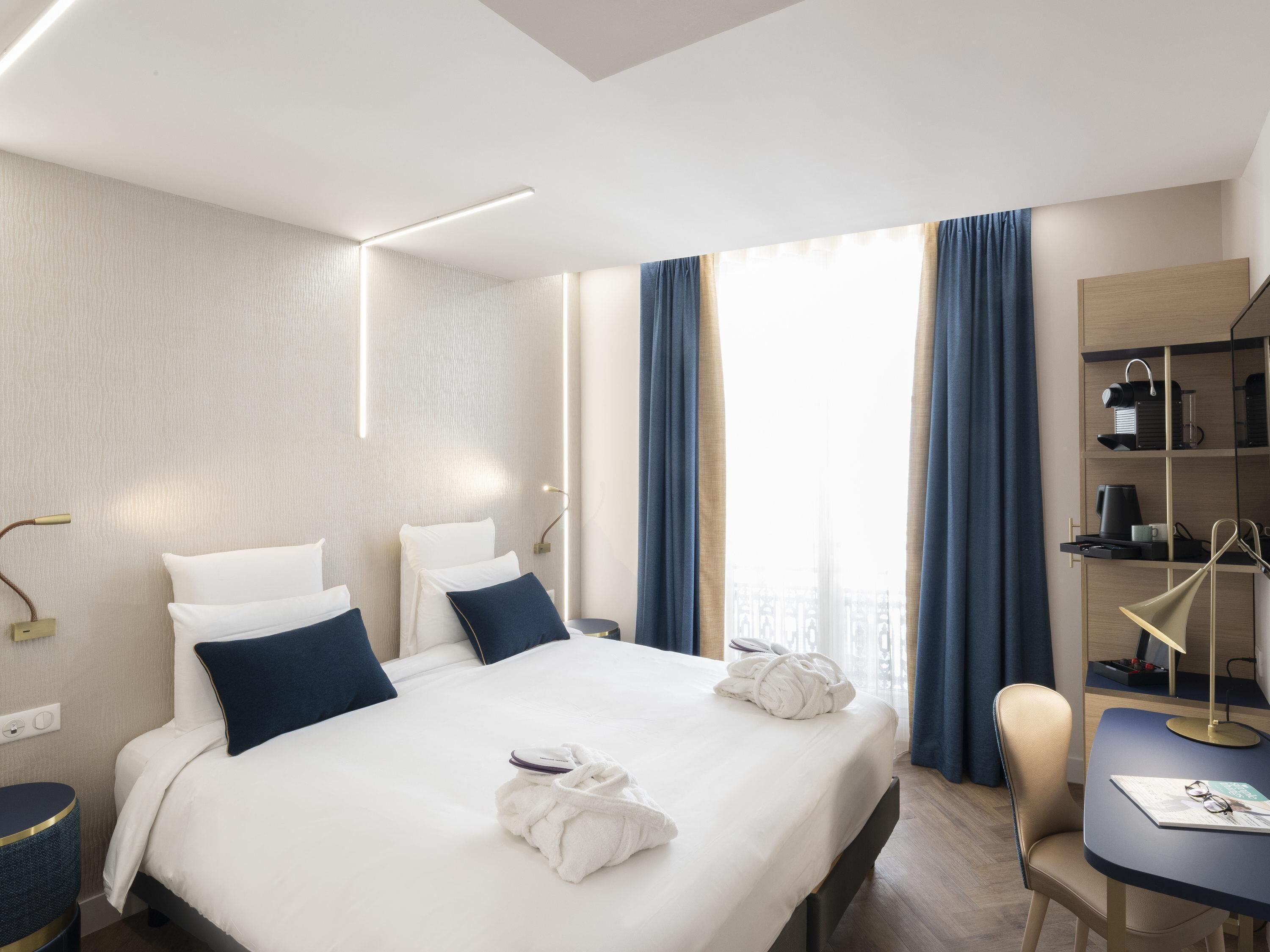 Une chambre d’hôtel comprenant un lit, des tables de chevet, un bureau et une chaise.