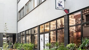 Ein modernes Gebäude mit großen Fenstern und einem Schild mit der Aufschrift 'KALIO KAFE'.