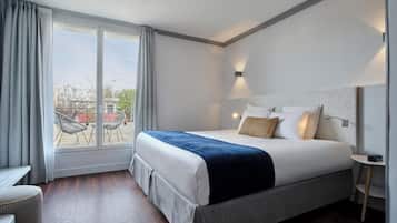 Une chambre d’hôtel moderne avec un grand lit, une petite table et une vue sur l’extérieur.