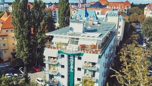 A hotel with a central tower, multiple balconies, and a rooftop garden. - Bernstein Villa Kastania (Berlin)