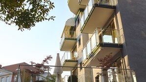 A multi-story building with balconies, potted plants, and a clear sky. - Bernstein Villa Kastania (Berlin)