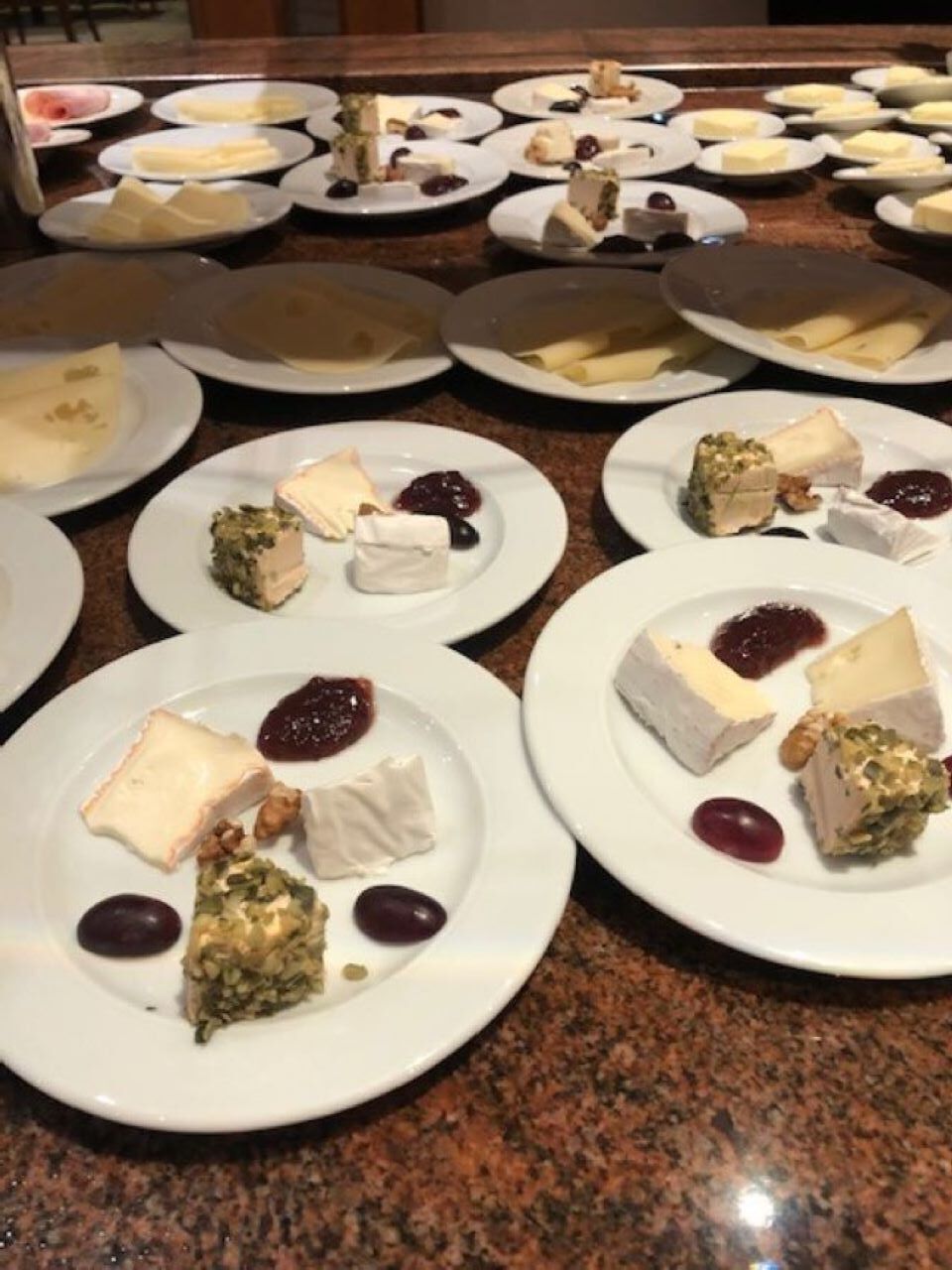 Une table de buffet avec différents types de fromages et de desserts.
