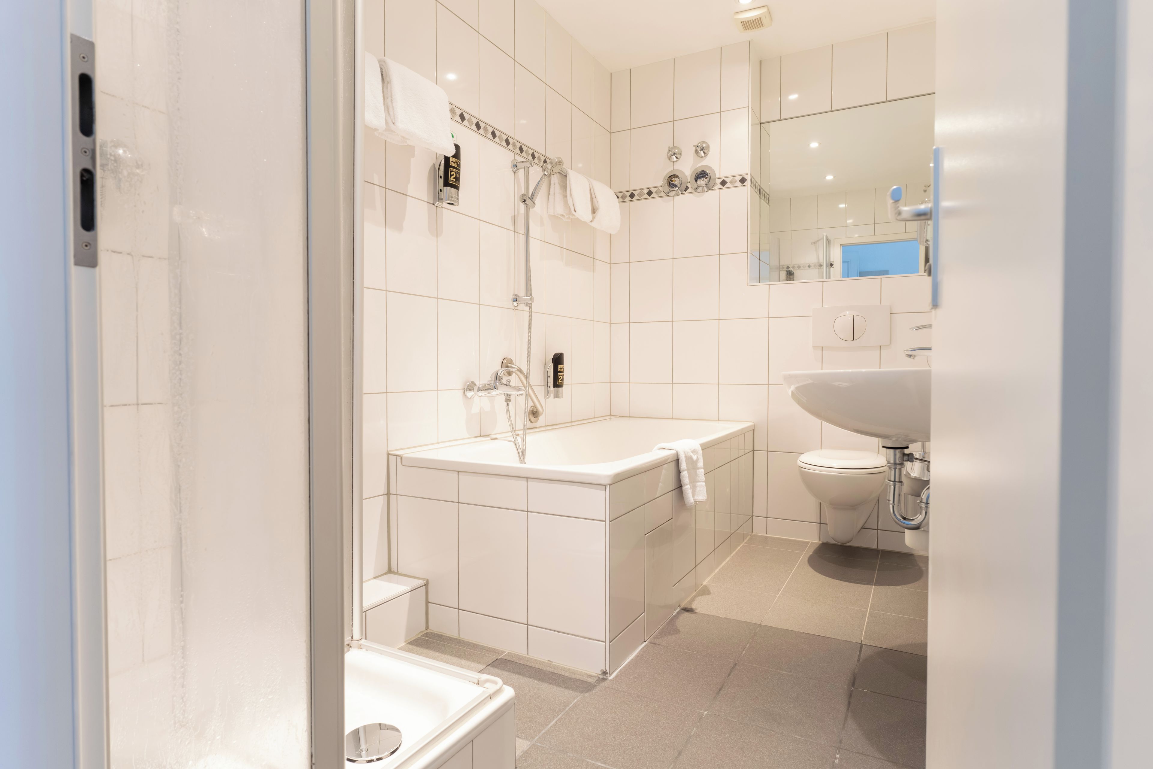 A modern bathroom with a bathtub, a sink, and a toilet.
