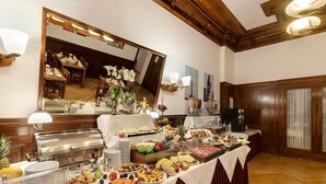 A buffet setup with various food items, a mirror, and a wooden ceiling. - Hotel Tiergarten Berlin (Berlin)