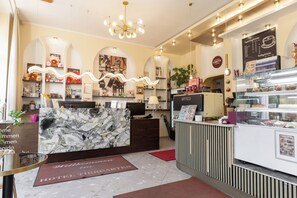 A hotel lobby with a reception desk, a coffee bar, and a menu board. - Hotel Tiergarten Berlin (Berlin)