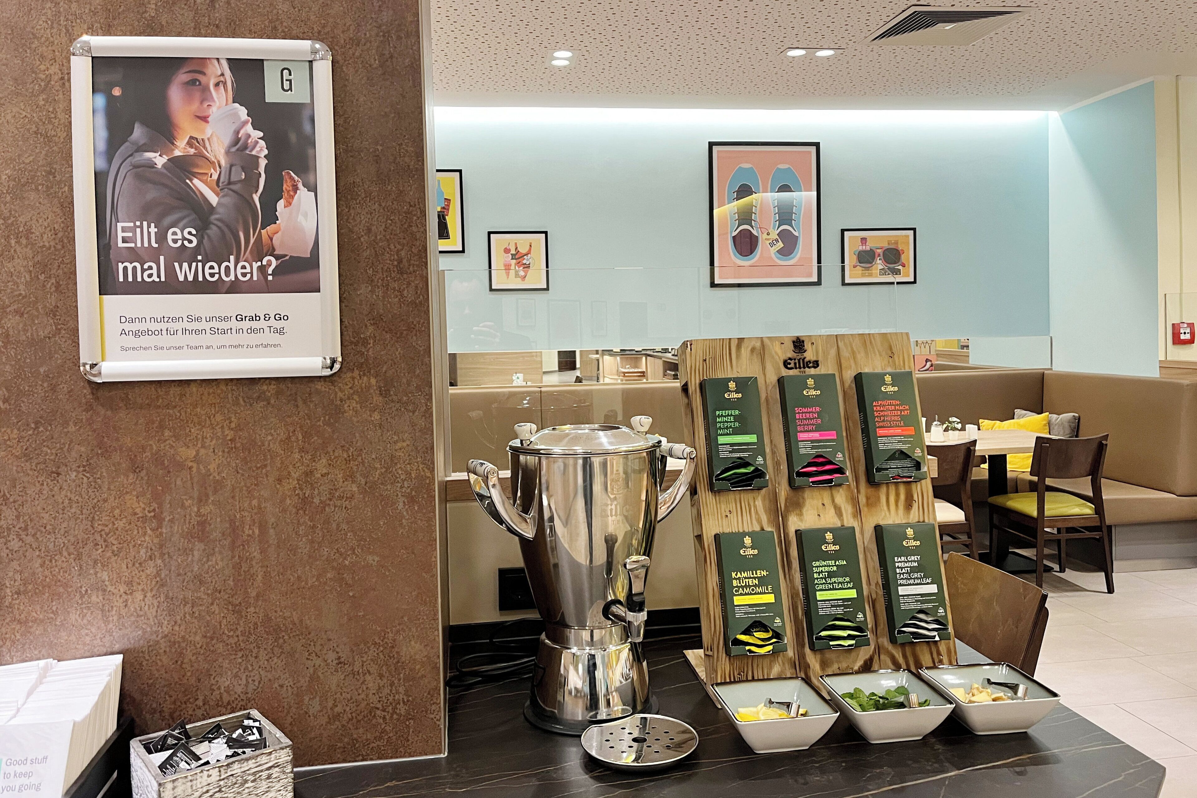 A restaurant interior with a coffee machine, menu boards, and seating areas.