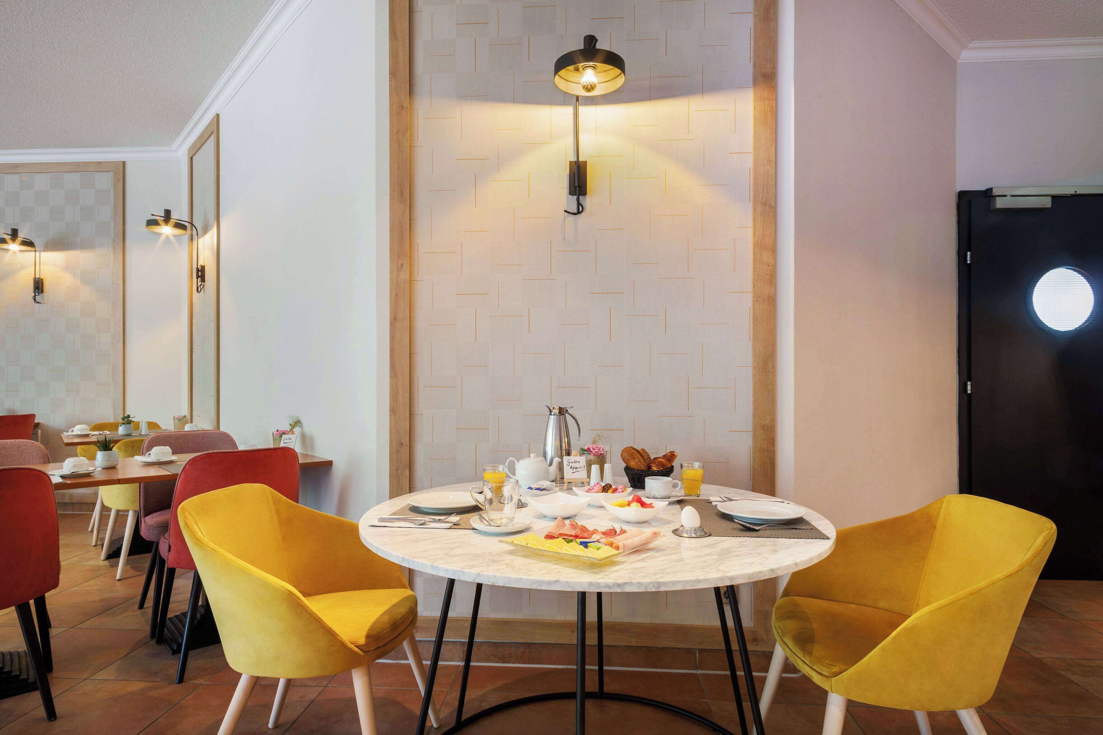 Un coin repas avec une table ronde, des chaises jaunes et des aliments pour le petit-déjeuner.
